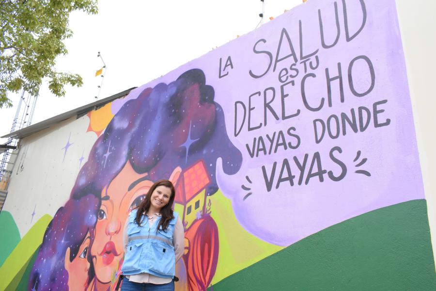 Lena Savelli frente a mural de Centro de Apoyo de Huaquillas