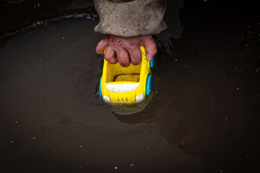 Mano de niño jugando con un carro de juguete en un charco de agua, en la comunidad de Pisambilla del cantón Cayambe ubicada en la Provincia de Pichincha, el 1 de Marzo del 2021.