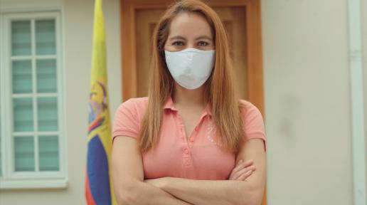 Imagen de mujer ecuatoriana con bandera en la parte posterior, usando mascarilla