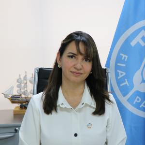 Imagen del rostro de Gherda Barreto, Representante de FAO en Ecuador, con la bandera de la Organización de fondo.